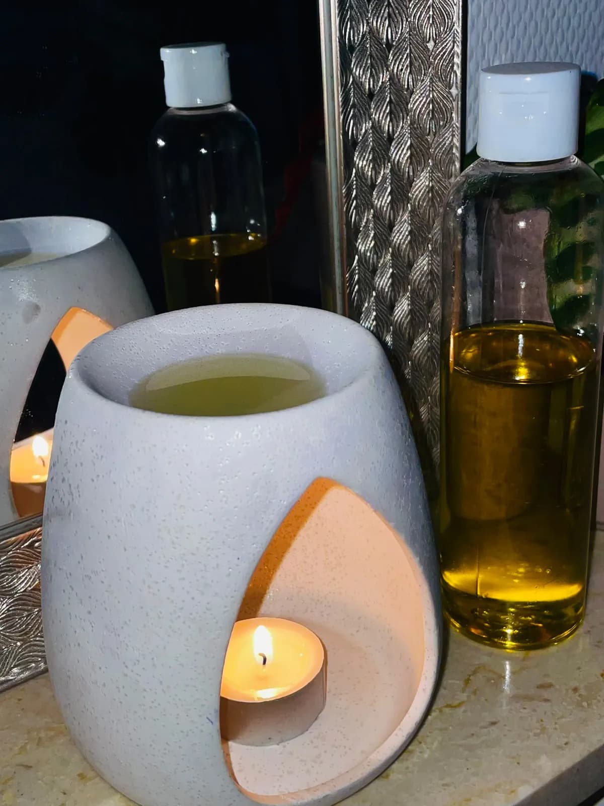 Huiles de massage et bougie allumée — l'espace bien-être installé chez vous